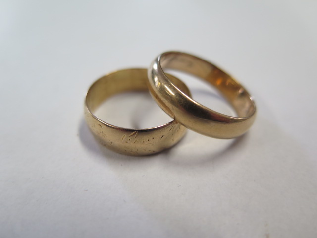 Two yellow gold band rings unhallmarked but test to approx 18ct, sizes T and Q, on has internal