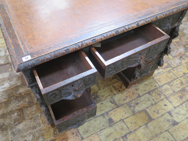 An oak kneehole writing desk with tooled leather top and ornate 'Green Man' carved drawers, 107cm - Image 6 of 6