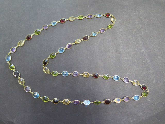 An 18ct yellow gold multigem sapphire, garnet, citrine, peridot necklace, approx 72cms long, total