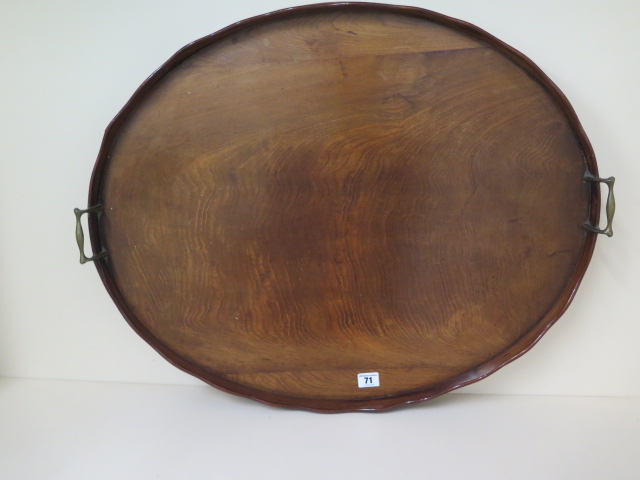 An early 1900s mahogany oval twin handle tray with a shaped rim, 71cm x 58cm