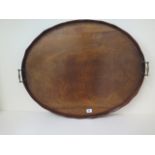 An early 1900s mahogany oval twin handle tray with a shaped rim, 71cm x 58cm