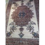 A large red ground rug with wide foliate border, 3.1m x 2.15m, signs of wear to edges and general