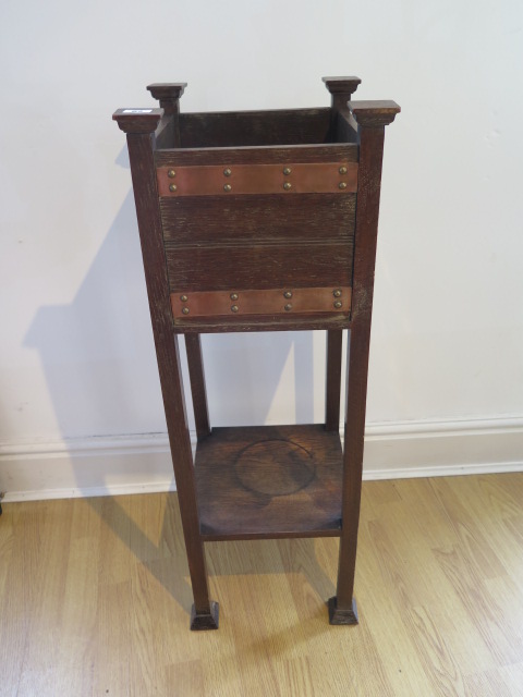 An oak Arts and Craft plant stand with copper banding, 93cm tall x 33cm square, some water