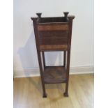 An oak Arts and Craft plant stand with copper banding, 93cm tall x 33cm square, some water