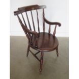 A 19th century elm penny seat armchair in polished condition