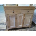 A Victorian stripped pine side cupboard with two drawers and two panel doors, 113cm tall x 124cm x