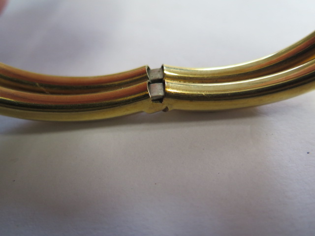 A sprung hinged 18ct hollow yellow gold bangle set with 4 small diamonds marked 750, 7.5cm x 6. - Image 3 of 4