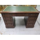 An early 1900's oak nine drawer twin pedestal desk with a leather inset top, 75cm tall x 122cm x