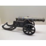 An ornamental brass cannon on cast iron carriage, 46cm long, some pitting but generally good