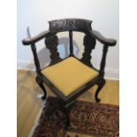 A 19th century carved oak corner chair with Green Man carving in good restored condition with a re-