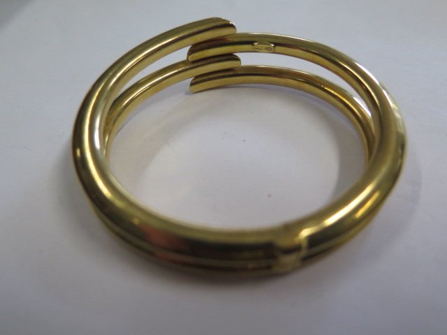 A sprung hinged 18ct hollow yellow gold bangle set with 4 small diamonds marked 750, 7.5cm x 6. - Image 4 of 4