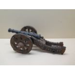 An ornamental bronze cannon on wooden carriage, 39cm long, some losses and wear