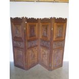 An oak four fold screen, the top carved with figural panels, the bottom carved with exotic wild