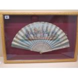 An early 19th century paper fan, decorated gallants and companions against a landscape over