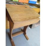 A pitch pine school desk with hinged lid and inkwell recess, 81cm high, 58cm wide, 47cm deep,