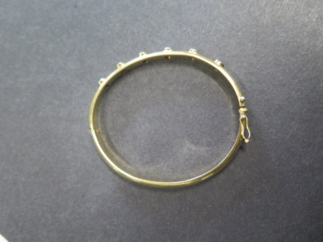 A yellow gold hinged bangle with 6 diamonds each approx 0.10ct, 6.5cm x 5.5cm external diameter, - Image 2 of 3