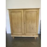 A Victorian stripped pine two door cupboard, 133cm tall x 123cm x 52cm, in waxed condition
