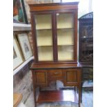 An Edwardian mahogany and line inlaid display cabinet, with glazed hinged doors enclosing two