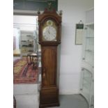 A good mahogany 8 day striking longcase clock with a silvered brass 12" arched dial, signed