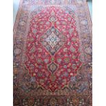 A hand knotted woollen Kashan rug, 2.12m x 1.45m, in good condition
