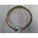 A yellow gold and white metal sprung coiled bangle, tests to approx 18ct, approx 23 grams, splitting