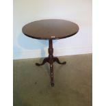 A Georgian mahogany tilt top tripod table with circular top, 65cm diameter, over a turned column and