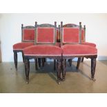 An early 20th century set of five oak and upholstered dining chairs with foliate carved crest and