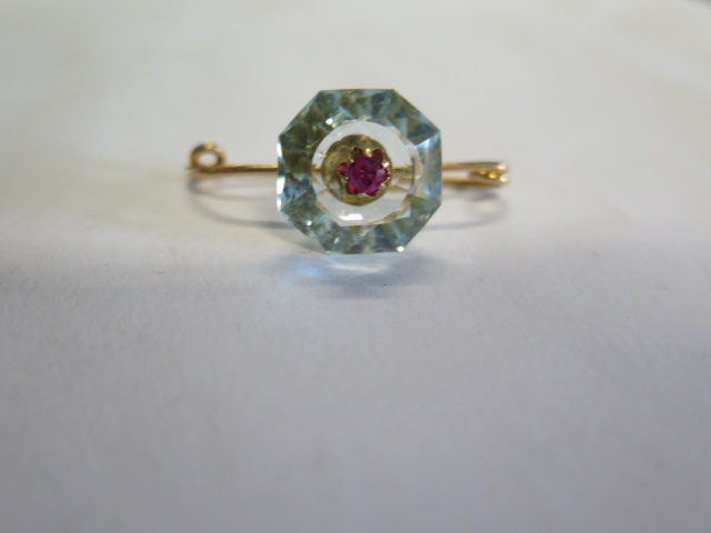 A French 18ct gold brooch with a Ruby set into a light blue hexagonal cut stone, possibly an