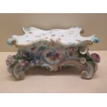 A Meissen porcelain clock base decorated with moulded flowers against a rectangular ground, blue
