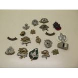 A collection of WWI and WWII cap badges and a LNER whistle