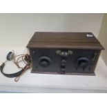 A vintage wooden radio receiver with headphones, 37cm wide