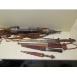 A tribal short sword, 69cm long and two daggers, all with sheaths and a quiver of arrows
