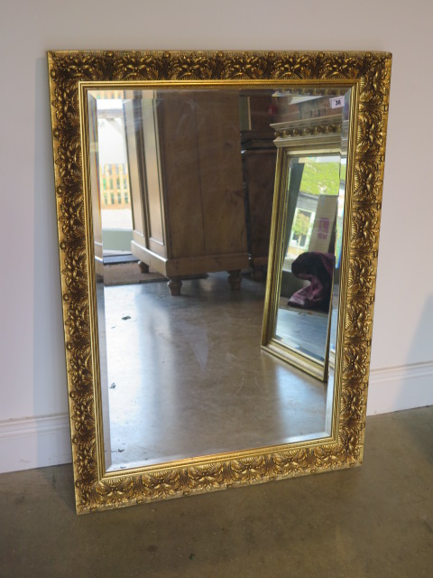 An ornate gilt mirror, 103cm x 75cm