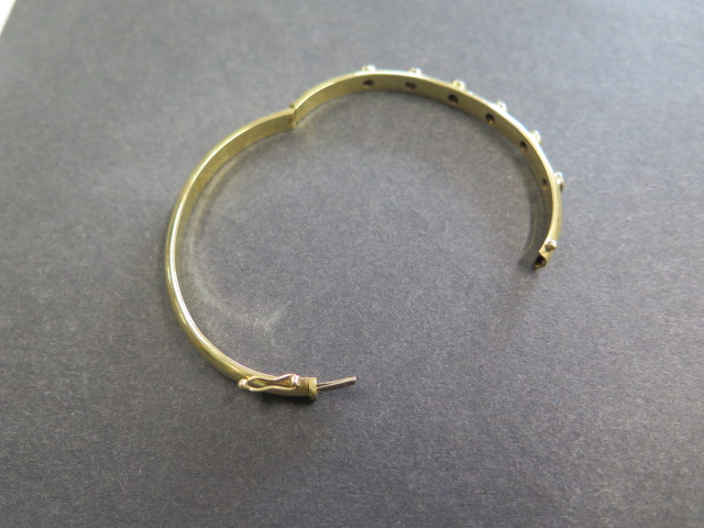 A yellow gold hinged bangle with 6 diamonds each approx 0.10ct, 6.5cm x 5.5cm external diameter, - Image 3 of 3