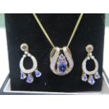 A hallmarked 9ct yellow gold tanzanite lolite and diamond pendant on a 44cm chain with matching