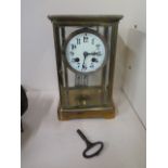 A brass four glass French mantle clock striking on a coiled gong, 25cm tall, not currently