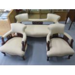 An Edwardian mahogany and upholstered salon suite comprising sofa and two armchairs, with cream