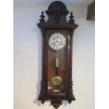 A 19th century walnut Vienna single weight wall clock, with a key, 124cm high