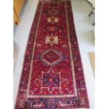 A hand knotted woollen Karajeh rug, 3.05m x 1.15m, in good condition