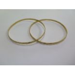 A pair of 18ct yellow gold bangles marked 18ct, 7cm diameter x 0.4cm, approx 18.2 grams, generally