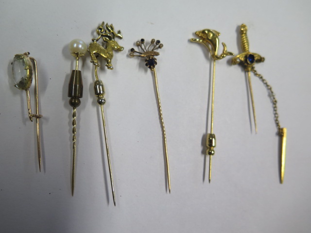 A collection of six tie pins including a sword, one pin marked 18ct, total weight with base metal