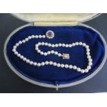 A string of pearls with a 9ct amethyst and pearl clasp, 43cm long, pearls approx 5mm wide, generally