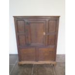 An 18th century oak panelled cupboard with a single central door, 148cm tall x 117cm x 50cm, some