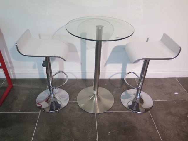 A glass top bar table, 91cm tall x 60cm diameter with two white laminated gas lift stools, some