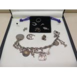 A silver charm bracelet with spare charms and a non silver coin, approx 2.2 troy oz, bracelet is