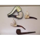 A collection of four pipes to include two Meerschaum Turkish head pipes, a cased pierced reticulated