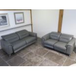 Two Furniture Village soft grey leather seater sofas with electric adjustable head and foot rests