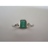 A 9ct hallmarked white gold emerald and diamond ring, size O/P, emerald approx 4mm x 6mm, in good