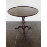 A low mahogany tripod table, 60cm tall x 56cm diameter, in generally good condition