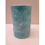 A Chinese 19/20th century brush pot with a moulded landscape scene covered in a turquoise glaze,